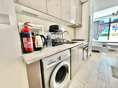a kitchen with a washing machine and a sink at Luxury studio appartment in Sabkhah