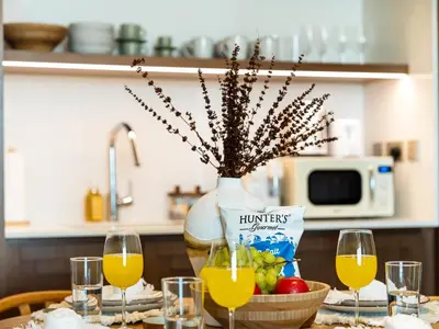a table with wine glasses and a jug of orange juice at Chic 1 Bedroom with Palm Views in Palace Beach Residence in Dubai