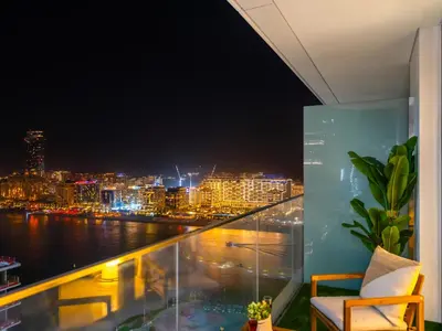 a balcony with a view of the city at night at Chic 1 Bedroom with Palm Views in Palace Beach Residence in Dubai