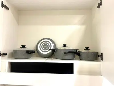 a shelf with three pots and a target on it at Premium Stylish Studio in JVC in Dubai