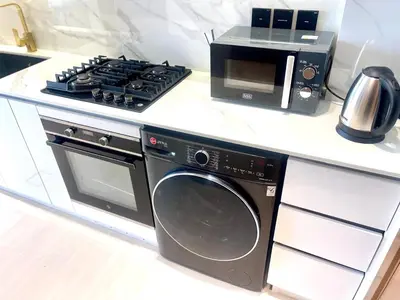 a kitchen with a microwave and a washing machine at Premium Stylish Studio in JVC in Dubai