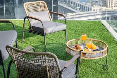 a table with two chairs and two glasses of orange juice at Luxury Apartments - Urban Oasis by Missoni - Business Bay - Canal View - 10 Minutes from Dubai Mall Burj Khalifa in Dubai