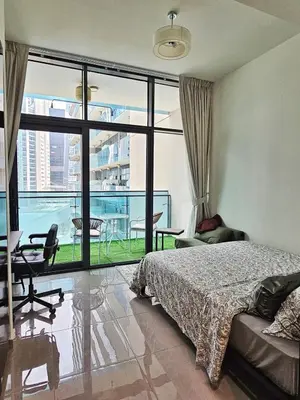 a bedroom with a bed and a balcony with a view at Merano Studio 920 in Dubai