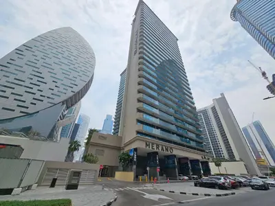 a mehran building with cars parked in a parking lot at Merano Studio 920 in Dubai