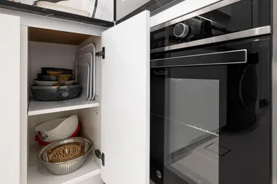 a kitchen with a microwave and a stove at BLVD Retreat - Luxury Oasis with Private Jacuzzi and Iconic Burj Khalifa Views in Dubai