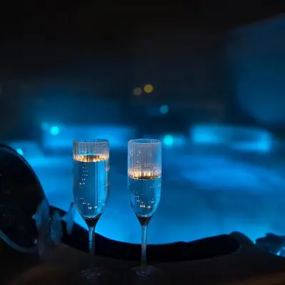 two glasses of champagne sitting on a table at BLVD Retreat - Luxury Oasis with Private Jacuzzi and Iconic Burj Khalifa Views in Dubai
