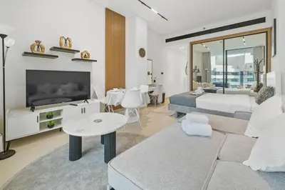 a living room with a bed and a couch and a tv at BLVD Retreat - Luxury Oasis with Private Jacuzzi and Iconic Burj Khalifa Views in Dubai