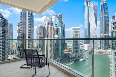 a balcony with two chairs and a view of the city at Luxury 4BR w Marina Views Near Beach & Mall in Dubai
