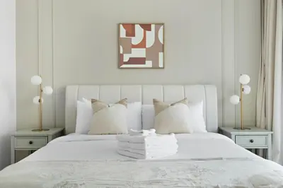 a white bedroom with a white bed with white pillows at Luxury 4BR w Marina Views Near Beach & Mall in Dubai