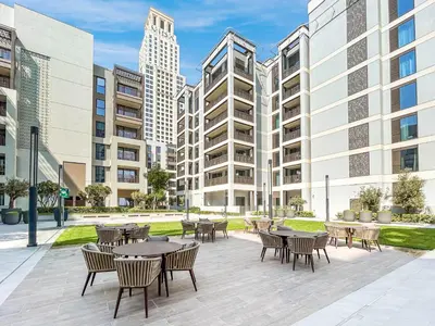a patio with tables and chairs and tall buildings at Creek Home with Private Terrace & Direct Pool Access in Dubai