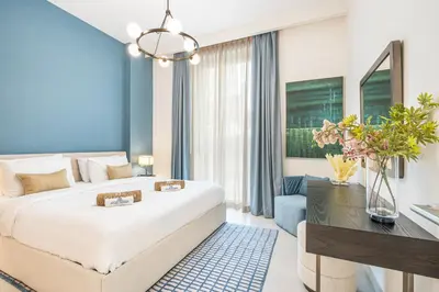 a bedroom with a large white bed and a desk at Creek Home with Private Terrace & Direct Pool Access in Dubai