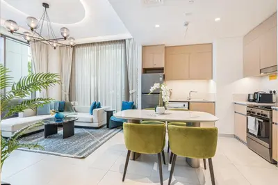 a kitchen and living room with a table and chairs at Creek Home with Private Terrace & Direct Pool Access in Dubai
