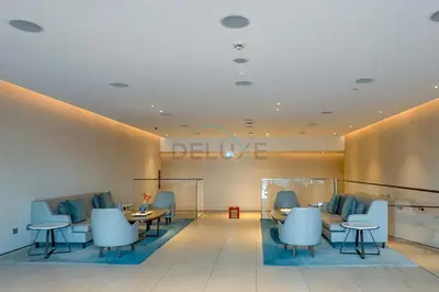 a waiting room with blue chairs and tables at 3BR Overlooking Sea, Ain Dubai, and Bluewaters Island, Walking Distance to the Beach, The Address Residences, Jumeirah Beach Residence by Deluxe Holiday Homes in Dubai