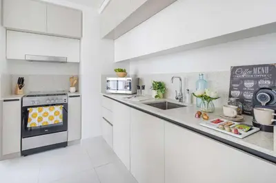 a white kitchen with a sink and a stove at Frank Porter - Marina Vista in Dubai