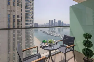 a table and chairs on a balcony with a view of a harbor at Frank Porter - Marina Vista in Dubai