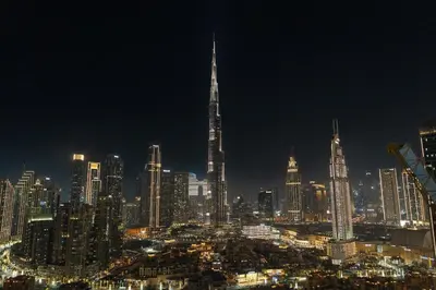 a night view of a city with a tall building at Panoramic Burj Khalifa View - Damac Distinction Downtown Dubai in Dubai