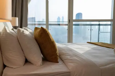 a bed with white pillows and a large window at Panoramic Burj Khalifa View - Damac Distinction Downtown Dubai in Dubai