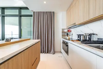 a kitchen with white countertops and a large window at Luxury Stay, 3BR Palm View, Beach Vista in Dubai