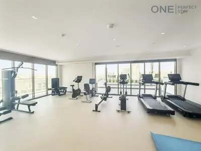 a gym with several treadmills and cardio machines at Modern 1-Bedroom Apartment in Al Furjan With Pool & Gym in Dubai