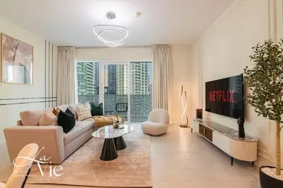 a living room with a couch and a tv at La Vie, JBR - Exclusive Beach & Pool Access in Dubai