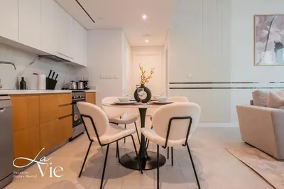 a kitchen and dining room with a table and chairs at La Vie, JBR - Exclusive Beach & Pool Access in Dubai