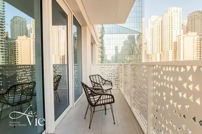 a balcony with chairs and a view of the city at La Vie, JBR - Exclusive Beach & Pool Access in Dubai