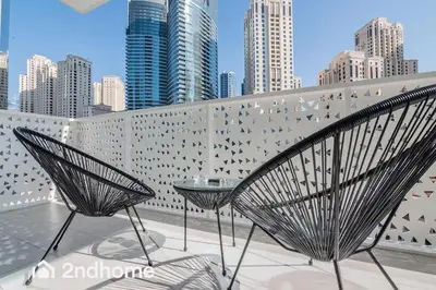 two chairs on a balcony with a city skyline at Newly Furnished, Beach Access located in La Vie, JBR in Dubai
