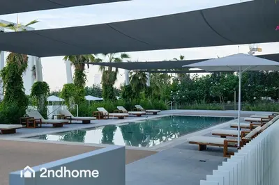 a swimming pool with chairs and umbrellas next to a pool at Newly Furnished, Beach Access located in La Vie, JBR in Dubai