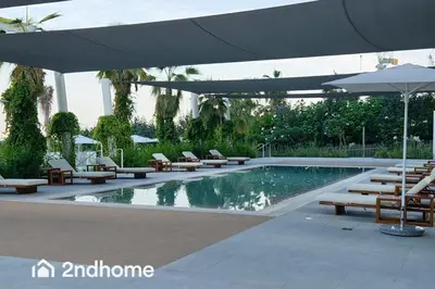 a swimming pool with lounge chairs and an umbrella at Newly Furnished, Beach Access located in La Vie, JBR in Dubai