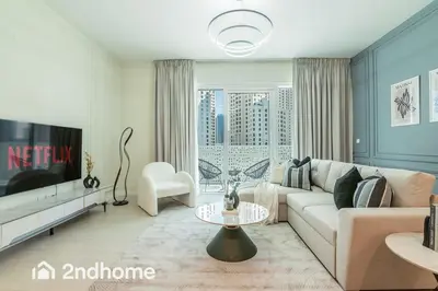 a living room with a couch and a tv at Newly Furnished, Beach Access located in La Vie, JBR in Dubai