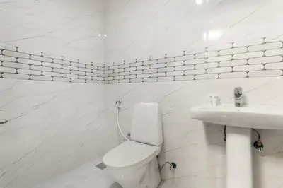 a white bathroom with a toilet and a sink at Luxury 3BR Gem in the Heart of Dubai Marina in Dubai