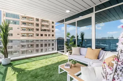 an apartment balcony with a couch and a large window at Luxury 3BR Gem in the Heart of Dubai Marina in Dubai