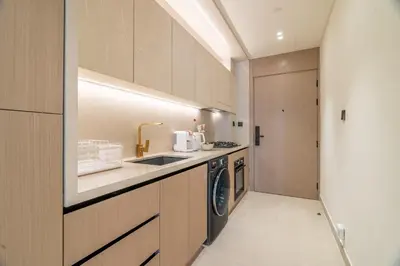 a kitchen with a sink and a washing machine at New! Stylish Studio with Pool, Gym & Jacuzzi, JVC in Dubai