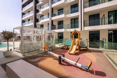 a playground in front of a building at New! Stylish Studio with Pool, Gym & Jacuzzi, JVC in Dubai