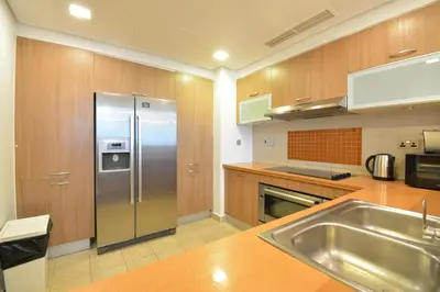 a kitchen with a stainless steel refrigerator and a sink at Near to Nakheel Mall Swimming Pool and Sea View in Dubai