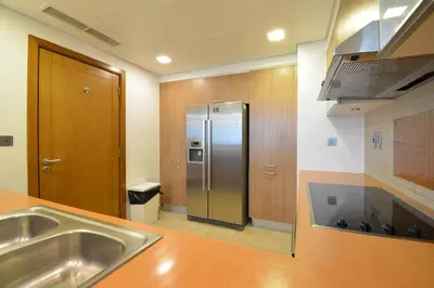 a kitchen with a stainless steel refrigerator in a room at Near to Nakheel Mall Swimming Pool and Sea View in Dubai