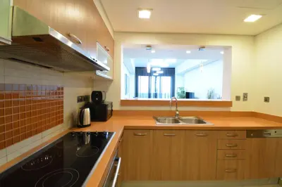 a kitchen with wooden cabinets and a sink and a window at Near to Nakheel Mall Swimming Pool and Sea View in Dubai