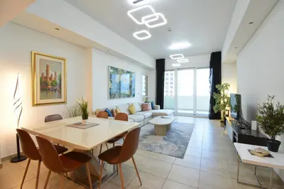 a living room with a table and a couch at Near to Nakheel Mall Swimming Pool and Sea View in Dubai