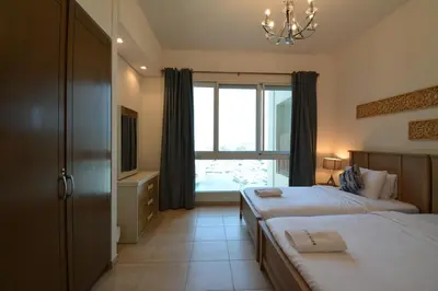 a bedroom with two beds and a window at Near to Nakheel Mall Swimming Pool and Sea View in Dubai