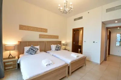 a bedroom with two beds and a chandelier at Near to Nakheel Mall Swimming Pool and Sea View in Dubai