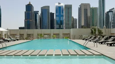 a swimming pool with chairs and a city skyline at DAYF-WST Stunning Marina Views at Marina Promenade in Dubai