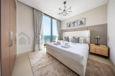 a bedroom with a large white bed with a large window at Tourist Spot, Sea View - Next to Bluewaters & JBR in Dubai