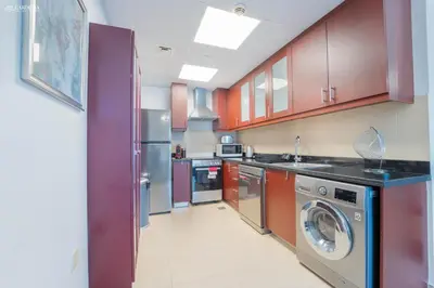 a kitchen with a washer and dryer in it at Gardenia Bahar Suites 1 Bedroom Apartment in JBR with 2 mins walk to the Beach in Dubai