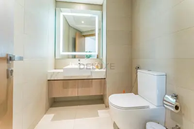 a bathroom with a toilet and a sink and a mirror at 1BR with Dubai Creek Views, Near Dubai Frame And Zabeel Park, Fawad Azizi Residence, Al Jadaf by Deluxe Holiday Homes in Dubai