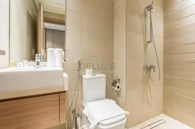 a bathroom with a toilet and a sink and a shower at Furnished Studio Near Meydan Racecourse, Minutes to Downtown Dubai, Azizi Riviera 47, Al Merkadh by Deluxe Holiday Homes in Dubai