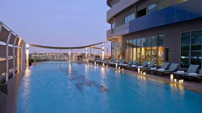 a large swimming pool on the side of a building at 2min to Dubai Mall - Pool, Gym, Sauna - Full Burj View in Dubai