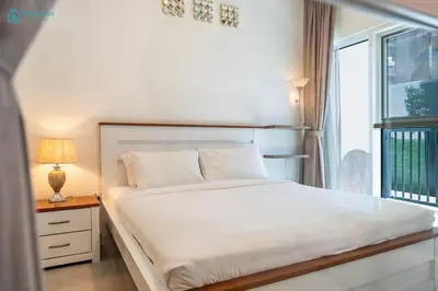 a bedroom with a white bed and a window at Blue Breeze - Modern 1BR, Dubai Hills, in Dubai