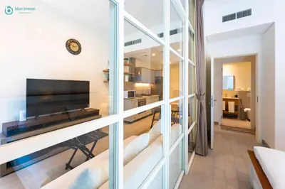 a view of a living room with a large window at Blue Breeze - Modern 1BR, Dubai Hills, in Dubai