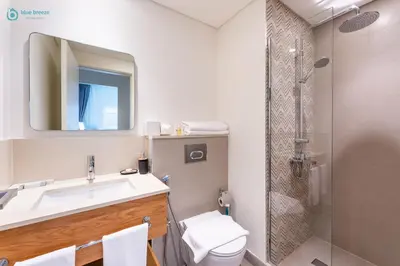 a bathroom with a sink and a shower at Blue Breeze - Modern 1BR, Dubai Hills, in Dubai