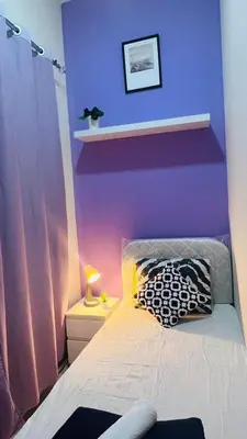 a bedroom with a purple wall with a bed at Solo Stay Partition Room in Al Barsha 1 in Dubai